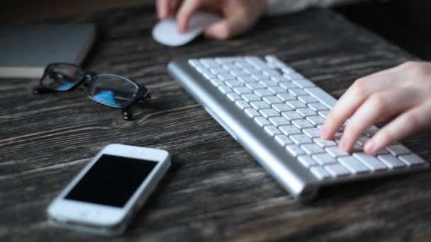 Un lugar de trabajo moderno. Trabajo nocturno. Un hombre se sienta en una computadora y escribe en el teclado . — Vídeos de Stock