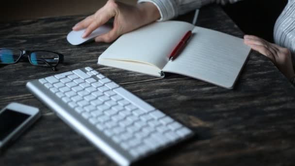 A young woman writing while sitting in her office at night — Stock Video