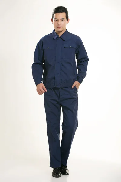 Genç mühendis çeşitli meslek kıyafetleri beyaz arka planda duruyor.