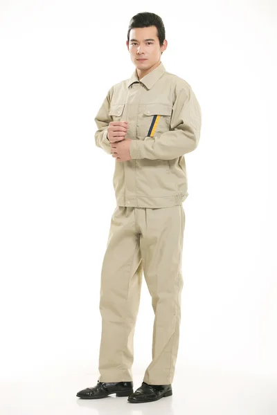 O jovem engenheiro várias roupas de ocupação em pé na frente de um fundo branco — Fotografia de Stock