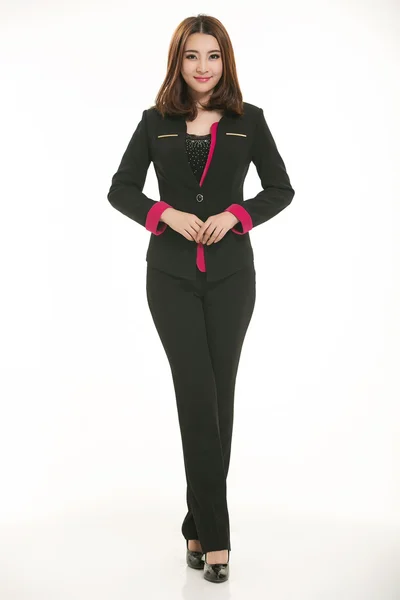 Beyaz arka plan önünde takım elbise giyen genç Asyalı kadınlar.