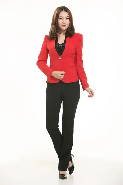 Beyaz arka plan önünde takım elbise giyen genç Asyalı kadınlar.