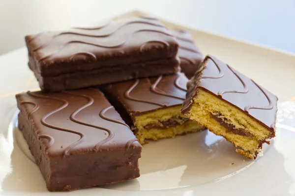 Nakrájený piškotový dort v čokoládě — Stock fotografie