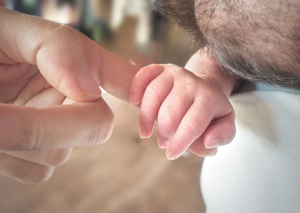 Baby holds mother's finger — Stock Photo, Image