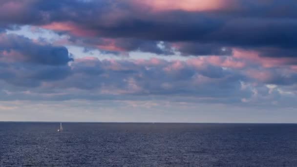 热带日落的迷人色彩 帆船的轮廓飘浮在海面上 黎明时分 游客们开始穿越大海的旅程 带着蓝色云彩的粉色 — 图库视频影像