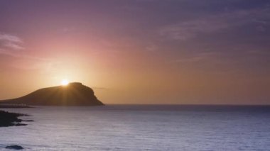 Tenerifedeki Kızıl Dağ kumlu plajı. Montana Roja, İspanya. Çıplak LGBT için kumsal. Doğal plaj. Güzel sakin sahne. Güneş ışığı su yüzeyine yansıyor. Playa de La Tejita 'da muhteşem bir gün doğumu.. 