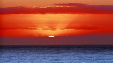 Romantik Günaydınlar. Güneş ufuktan inanılmaz bir güzellikte yükselir. Güneş ışınları okyanusun üstünde, Güneş ışınları okyanusun üstünde, su yüzeyi gün batımında yavaş çekimde..