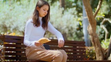 Çocuk sokağın ortasına ekmek atıyor. Güneşli parkta güvercinleri elleriyle besleyen zarif bir kız. Hayvanları doğada besliyor. Kötü alışkanlık..