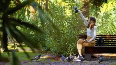 Kız vahşi hayata alışıyor. Parkta canlı kuşla oynayan komik genç kız. Genç kız ve telefon.. 