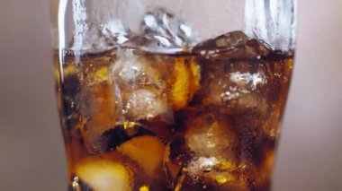Makro Cola Baloncukları ve Buz Küpleri yakın planda buzlu bir bardakta. Doğal buzlu kola ve kabarcıklar. Susuzluğunuzu lezzetli bir içecekle giderin. 