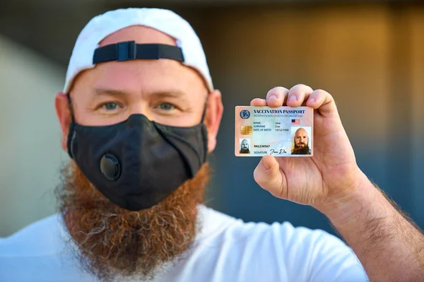 Dokunulmazlık ya da sağlık pasaportu. Amerikan Aşı Belgesi. Çantalı turist, aşı ve sağlık belgesi gösteriyor.. 