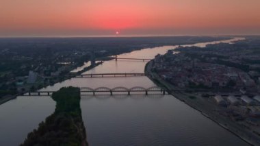 Riga, Letonya, Baltık. Old Riga Center 'da panoramik hava aracı, Daugava Nehri' nin arka planında ve şehir merkezinde demiryolu köprüsü. Gece vakti ünlü tren köprüsü ve eski market Letonya