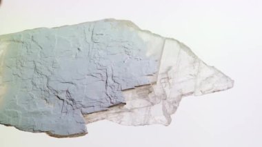 Büyük alçı taşı kristalleri. Beyaz arka planda alçı taşları. Alçı taşı, alçı taşı ve alçıpan üretimi için ham madde. Yenileme, inşaat, alçıpan. Dikey video.