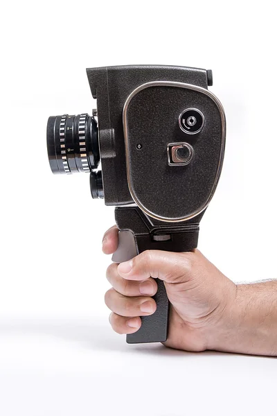 Рука держит винтажную кинокамеру изолированную на белом — стоковое фото