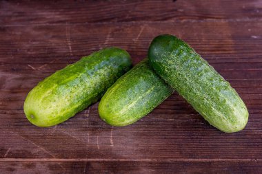 Ahşap bir arka plan üzerinde üç salatalık