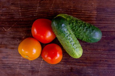 Taze, olgun domates ve salatalık görünümünü geri ahşap üzerine kapatın