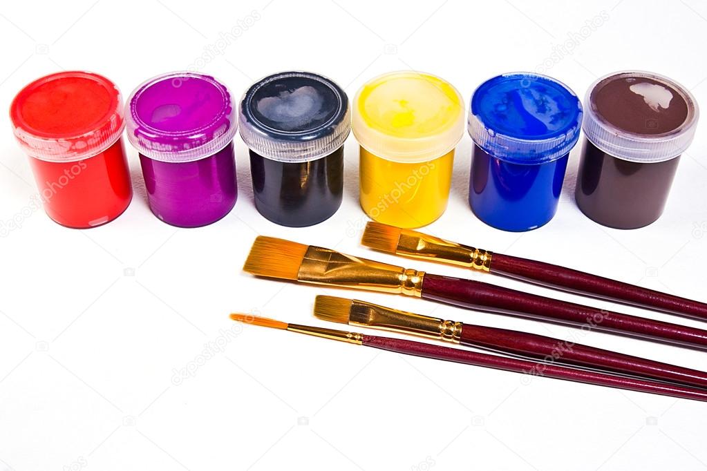 Bottles with gouache paints and different kinds of brushes for a