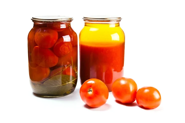 Glass jars of canned tomatoes and tomatoes juice on white backgr — Stock Photo, Image