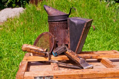 Old smoker and other tools on the wooden box.