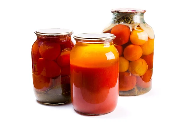 Glass jars of canned tomatoes and tomatoes juice on white backgr — Stock Photo, Image