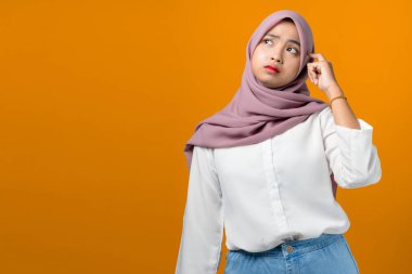 Sarı arka planda düşünen ve hisseden Asyalı genç kadın.