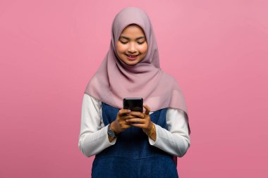 Genç Asyalı kadın cep telefonu kullanarak gülümsüyor.