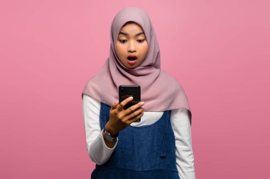 Genç Asyalı kadın cep telefonu kullanırken şok oldu.