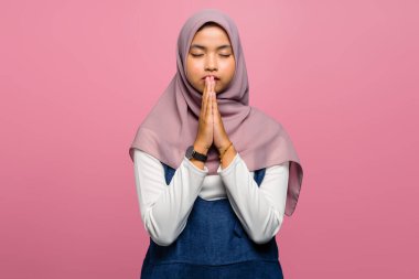 Katlanmış elleriyle dua eden Asyalı genç bir kadın.