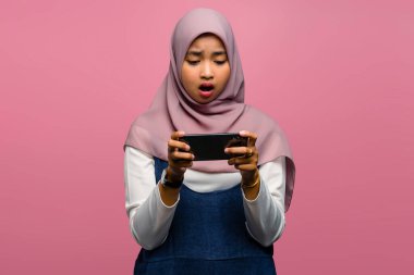 Genç Asyalı kadın video oyunu oynuyor ve mutsuz görünüyor.