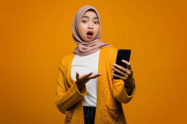 Güzel Asyalı kadın şok olmuş bir suratla akıllı telefon kullanıyor.