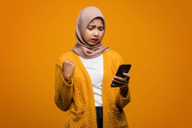 Güzel Asyalı kadın kızgın suratlı akıllı telefon kullanıyor.