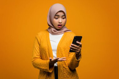 Güzel Asyalı kadın şok olmuş bir suratla akıllı telefon kullanıyor.