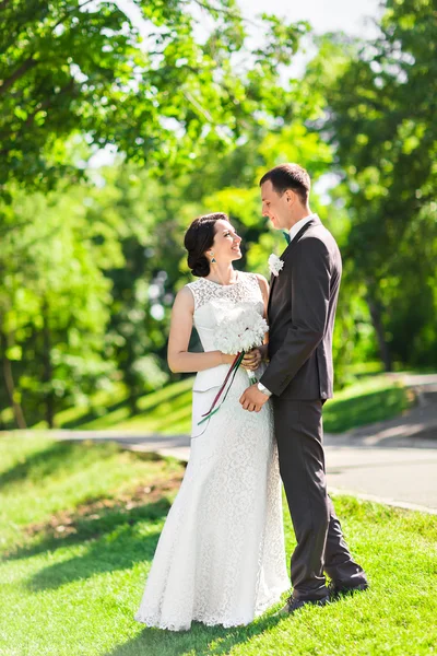 Bela noiva e noivo ao ar livre em um parque . — Fotografia de Stock