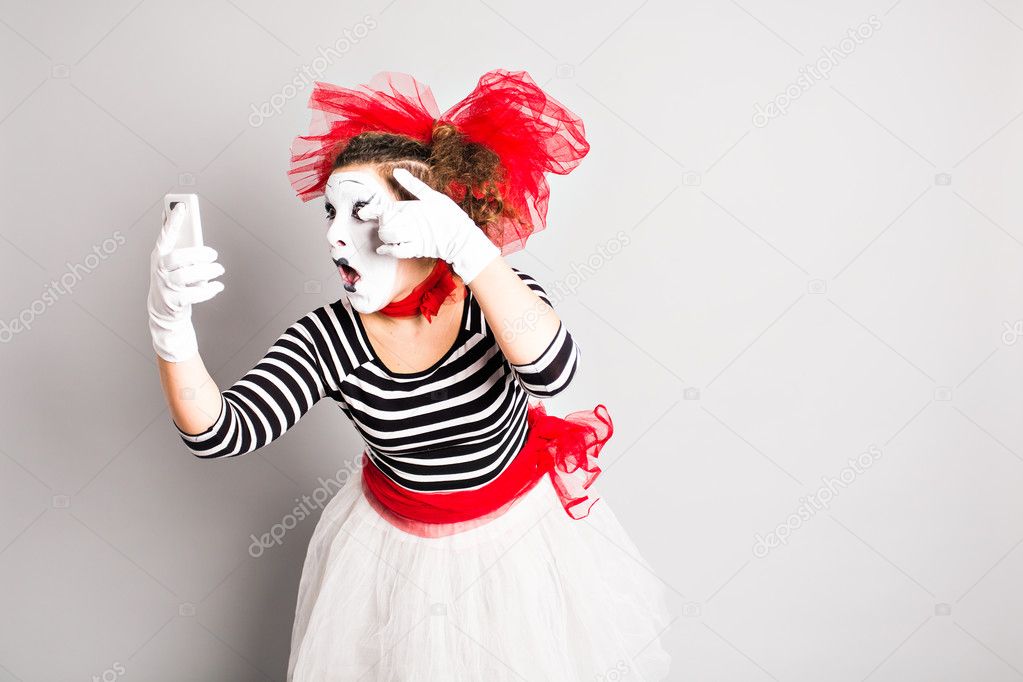 April Fools Day concept.  Mime holding cell phone.