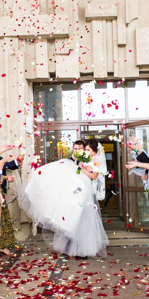 Invités jetant des confettis sur la mariée et le marié au mariage — Photo