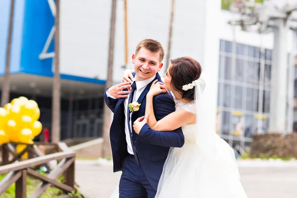 Portrait de mariée et marié heureux riant dans la rue à la journée ensoleillée — Photo