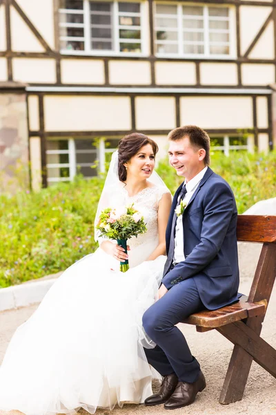 Romantici sposi seduti su una panchina nel parco — Foto Stock