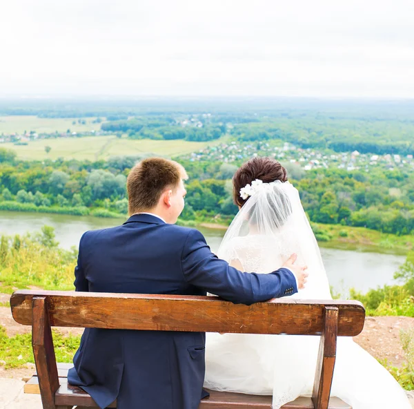 Romantik Düğün çifti parkta bir bankta oturan — Stok fotoğraf