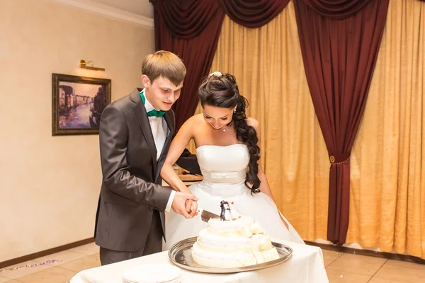 Braut und Bräutigam schneiden ihre Hochzeitstorte an — Stockfoto