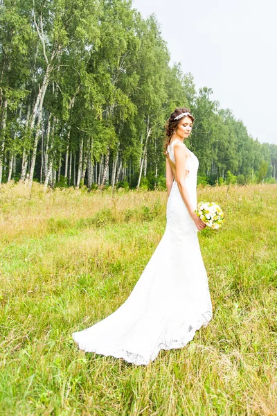 Mooie bruid buiten in een veld. — Stockfoto