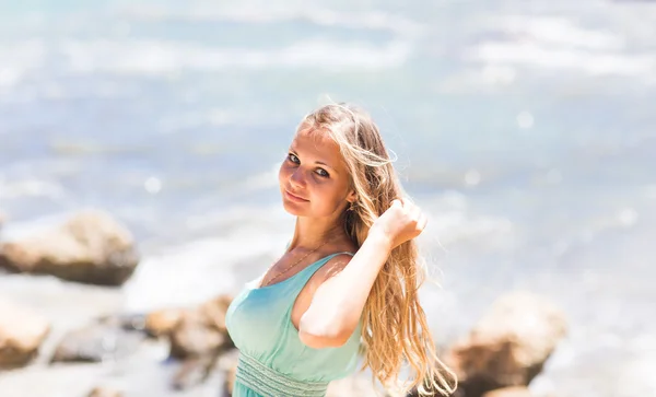 Joven mujer de pie cerca de la playa mar en vestido azul — Foto de Stock