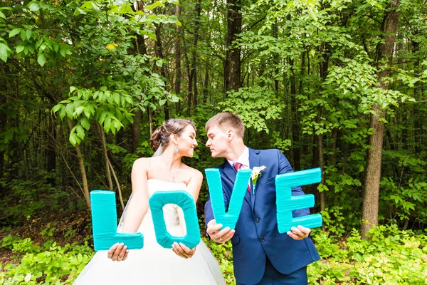 Novia feliz y novio sosteniendo cartas de AMOR — Foto de Stock