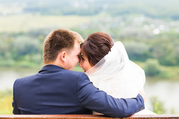 Nevěsta a ženich s romantickým posezením na jejich svatební den — Stock fotografie