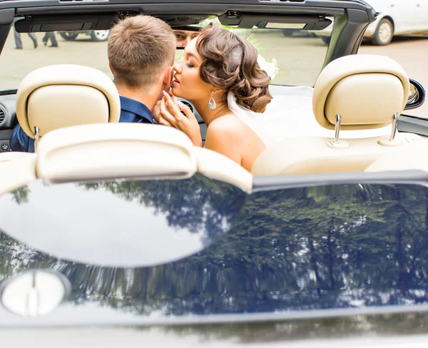 Gyönyörű fiatal pár menyasszony és a vőlegény pózol cabriolet — Stock Fotó