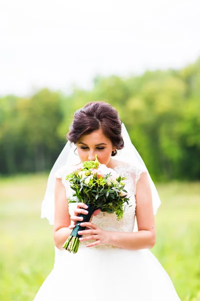 아름 다운 신부 여자 야외 초상화 꽃의 부케와 웨딩 드레스 — 스톡 사진