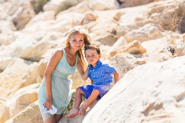 Smiling mother  and her little son. Yellow rocks and stones. Concept of mothers Day. Family outdoors portrait.