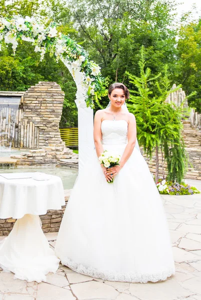 Bella sposa ragazza in abito da sposa con mazzo di fiori, ritratto all'aperto — Foto Stock