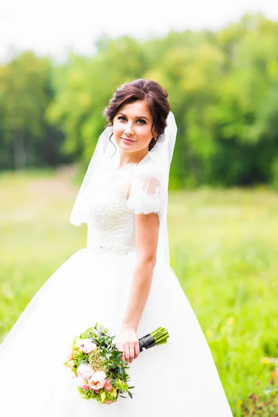 Jovem noiva segurando grande buquê de casamento — Fotografia de Stock