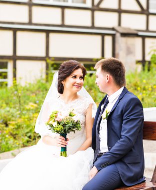 romantik Düğün çifti parkta bir bankta oturan