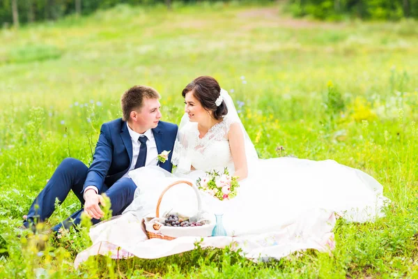 Joyeux jeune couple de mariage sur le pique-nique dans le parc — Photo